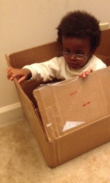 Child playing with cardboard box